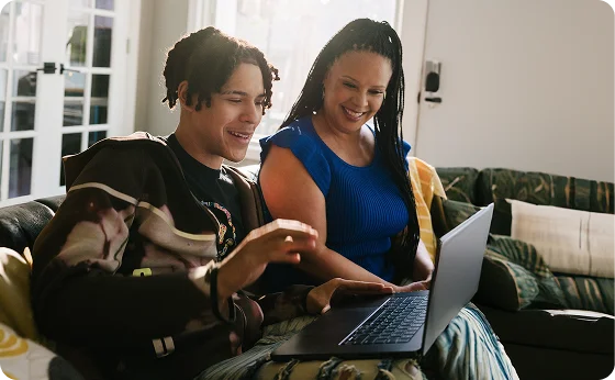 Mother and her son working with their laptop