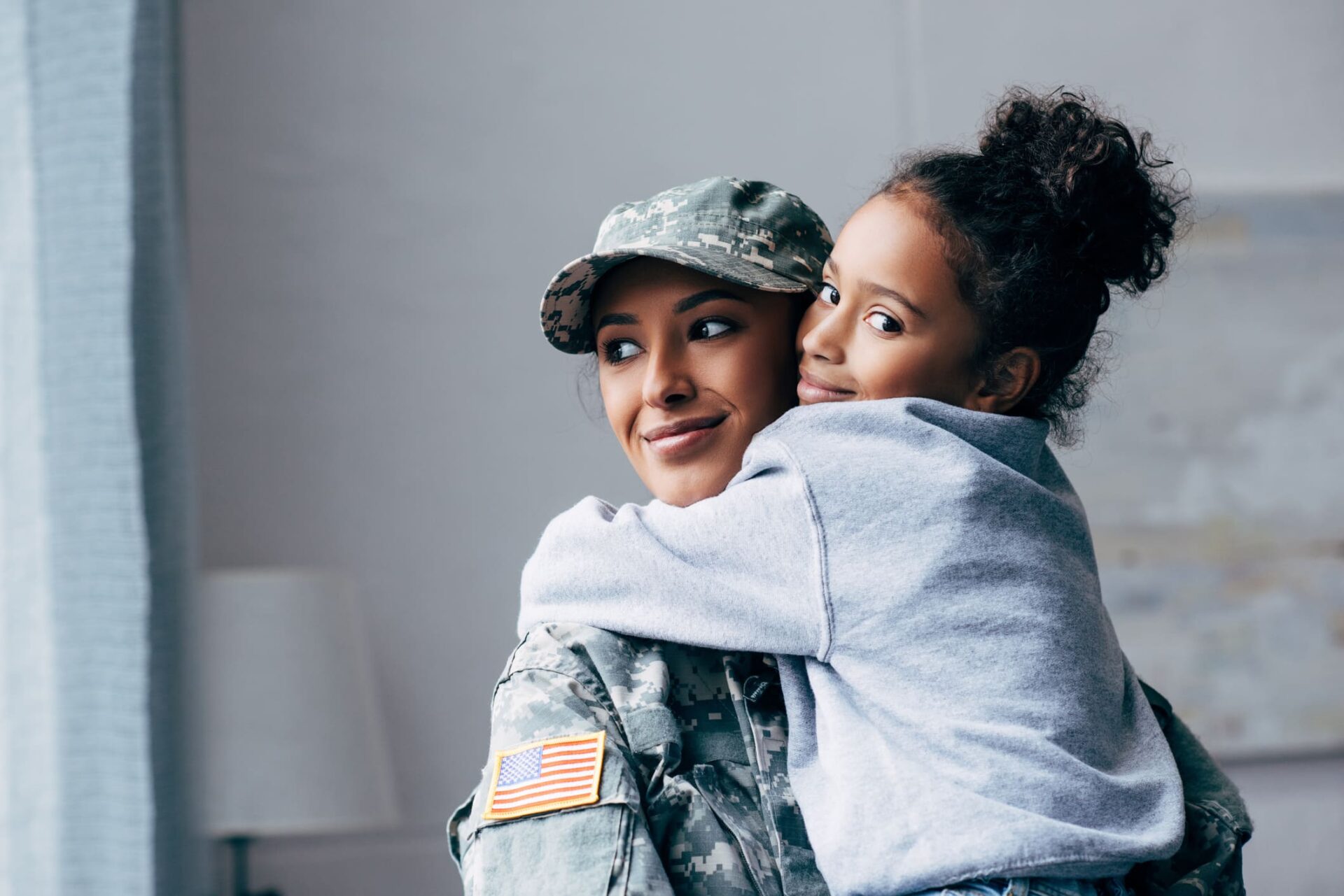 Women waring a military uniform hugging a girl